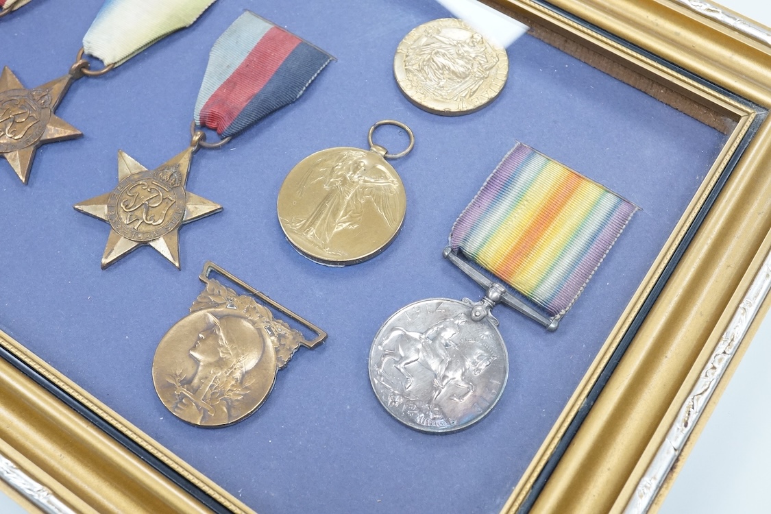 Framed group of eight WWI and WWII medals including a First World War medal pair, the Africa star, the Atlantic star, etc. a hallmarked silver boxing medal and another, both cased, plus a Lancashire and Cheshire Associat